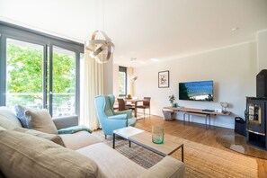 A modern living room with a sofa, a coffee table, a TV, and a fireplace.
