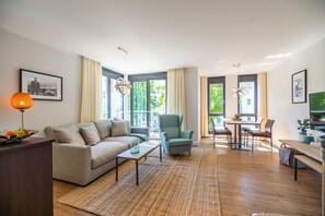 Un salon moderne comprenant un canapé, un fauteuil, une table basse et un coin repas.