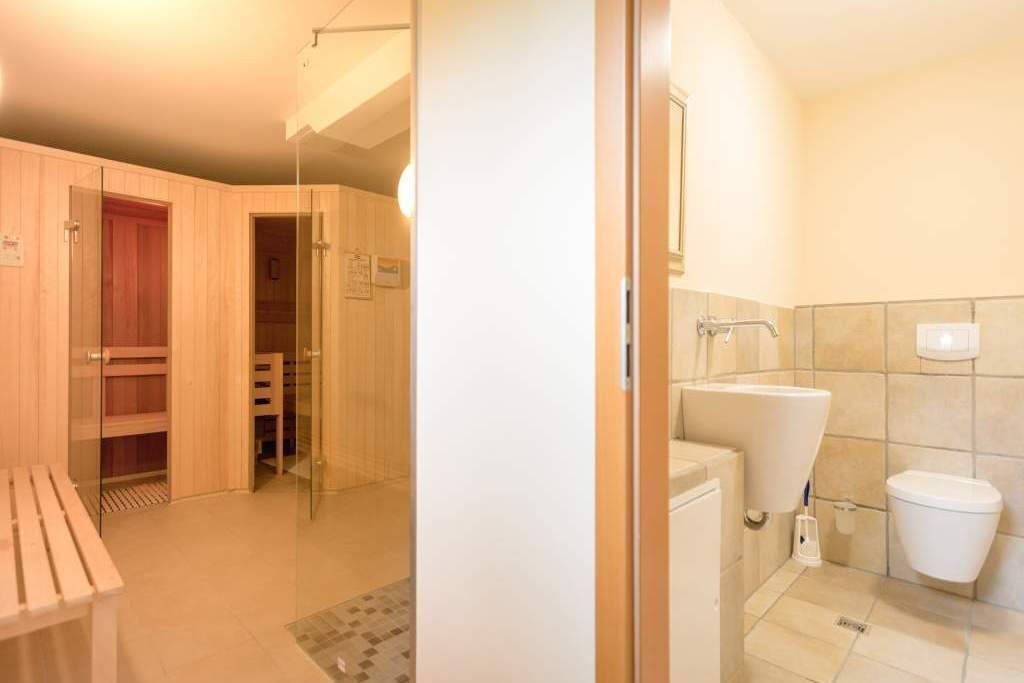 Ein Badezimmer mit Toilette, Waschbecken und Duschbereich.