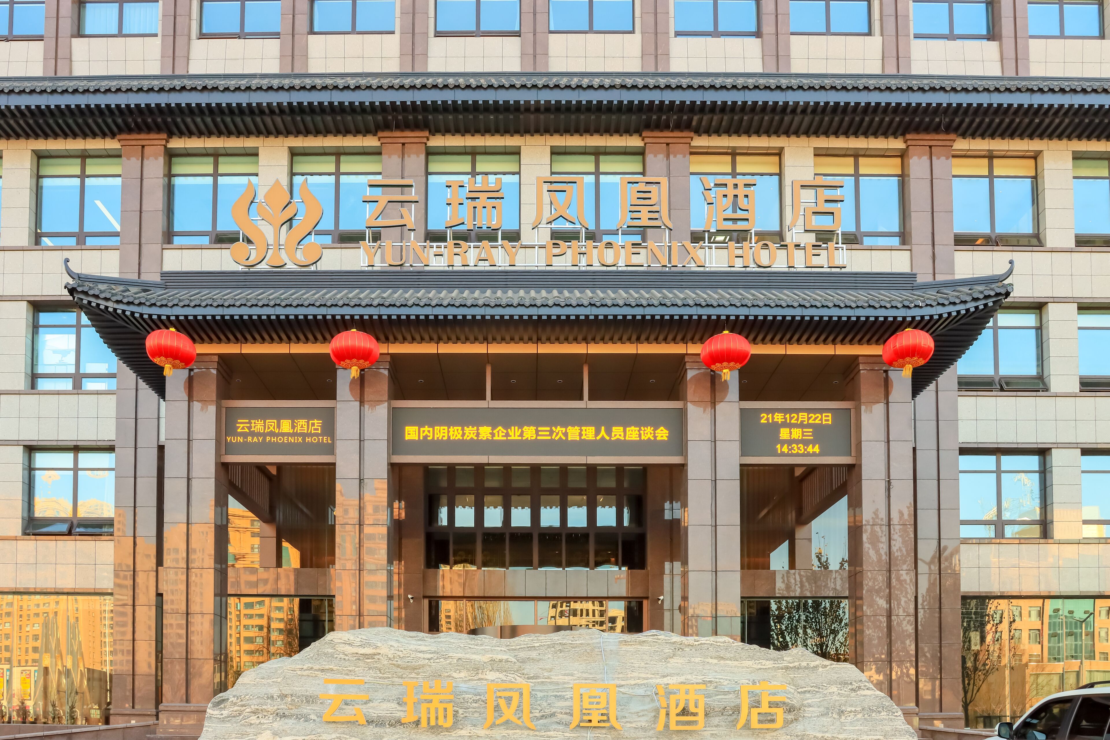 The exterior of Yun-Ray Phoenix Hotel with traditional architectural elements and a large stone base.