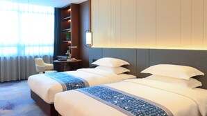 A hotel room with two beds, a desk, a chair, and a bookshelf. - YUN-RAY PHOENIX HOTEL (Jinzhong)