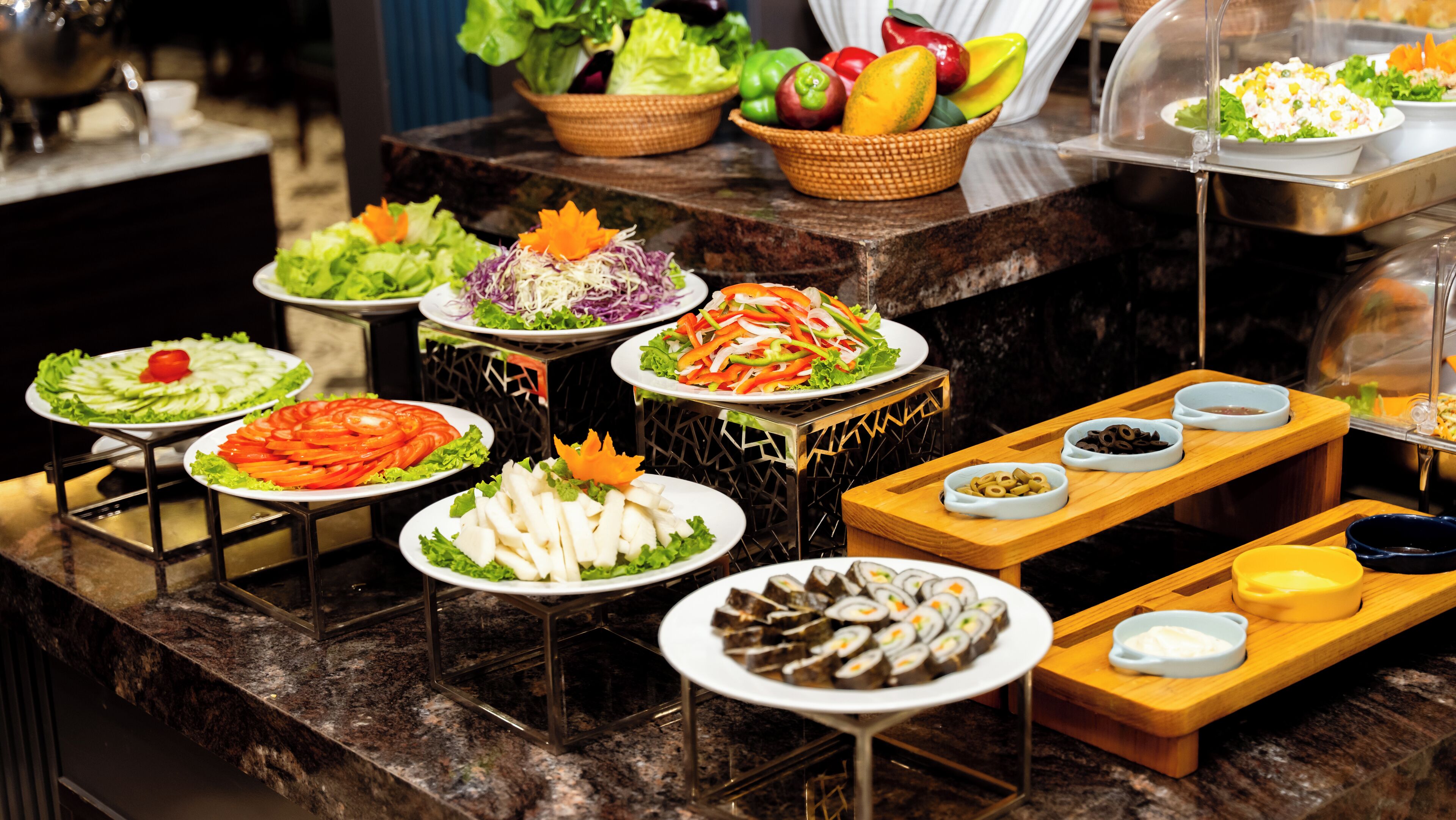 A buffet with various dishes including salads, vegetables, and sushi.