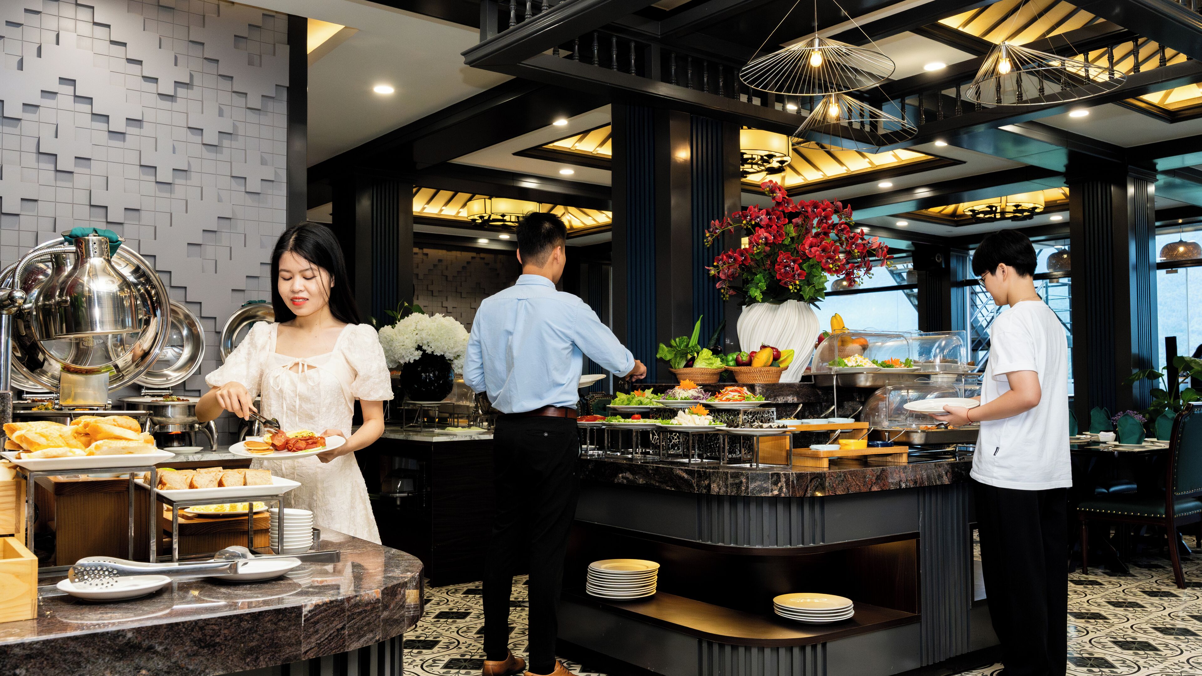A buffet setup with various food items and a decorative vase of flowers.