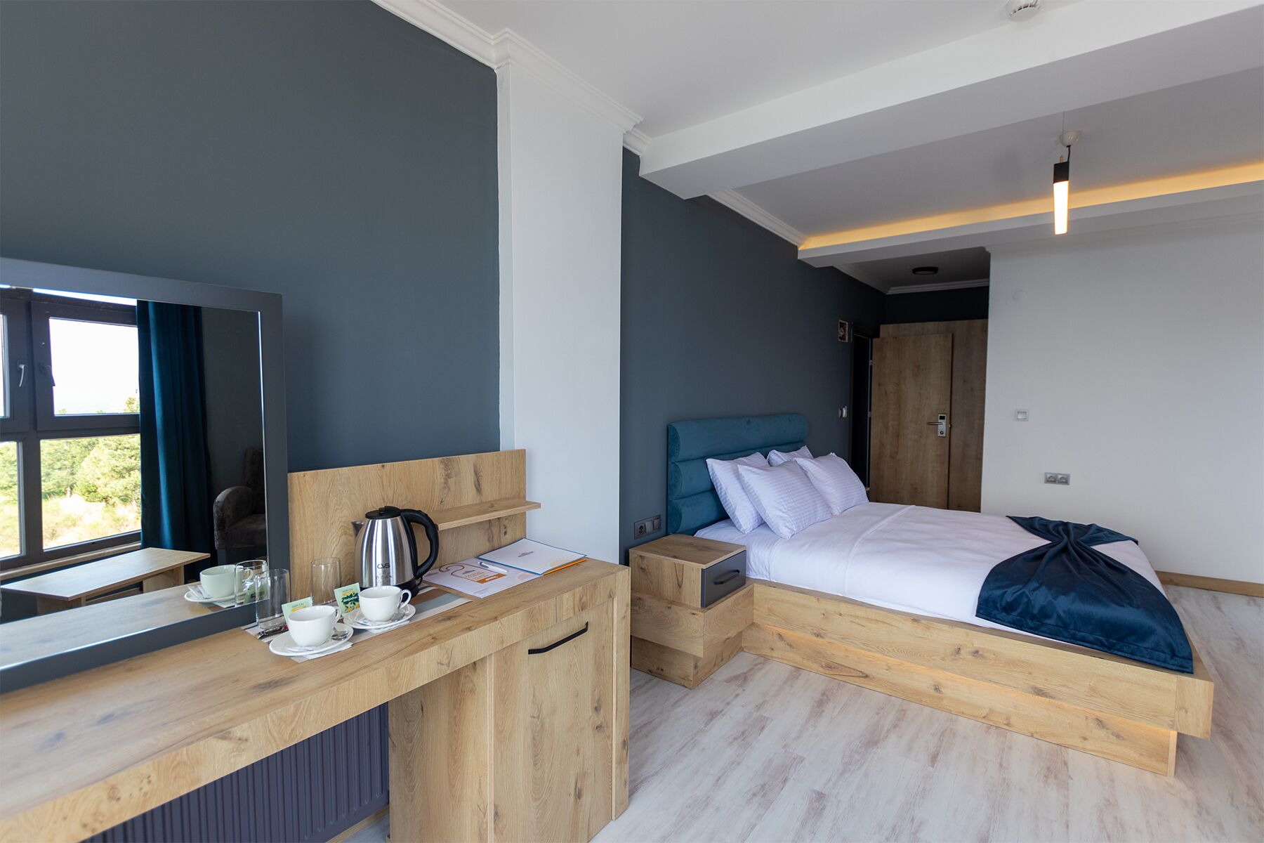 A modern bedroom with a bed, bedside table, and a TV.