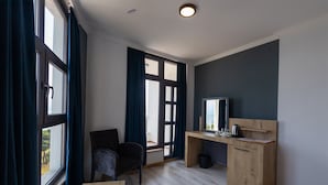 A modern room with a wooden desk, a chair, and a large window with curtains. - Sunrise Hotel (Sinop)