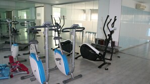 Uma academia com diversos equipamentos de exercício, incluindo esteiras e bicicletas ergométricas.