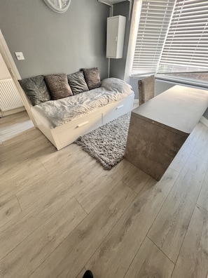 Relax in this stylish living room with a white sofa, side table, and large window.