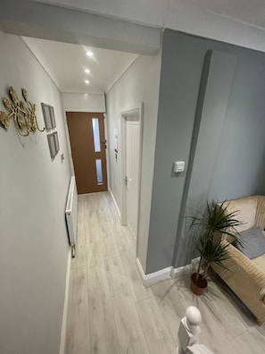 Stylish hallway with a radiator, sofa, and potted plant.