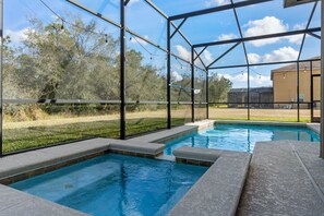Une piscine offrant une vue dégagée sur le paysage environnant, notamment sur les arbres et un bâtiment situé au loin.