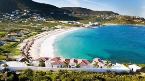 A coastal resort with beachfront villas, a sandy beach, and a mountainous backdrop. - Villa Amalia – 6-Bedroom Luxury Oceanview Villa with Pool, Gym & Full Staff in St. Maarten (Philipsburg)