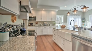 A modern kitchen with white cabinetry, granite countertops, stainless steel appliances, and pendant lighting. - Morrisonville Manor w/ Fire Pit & Hot Tub! (Lovettsville)