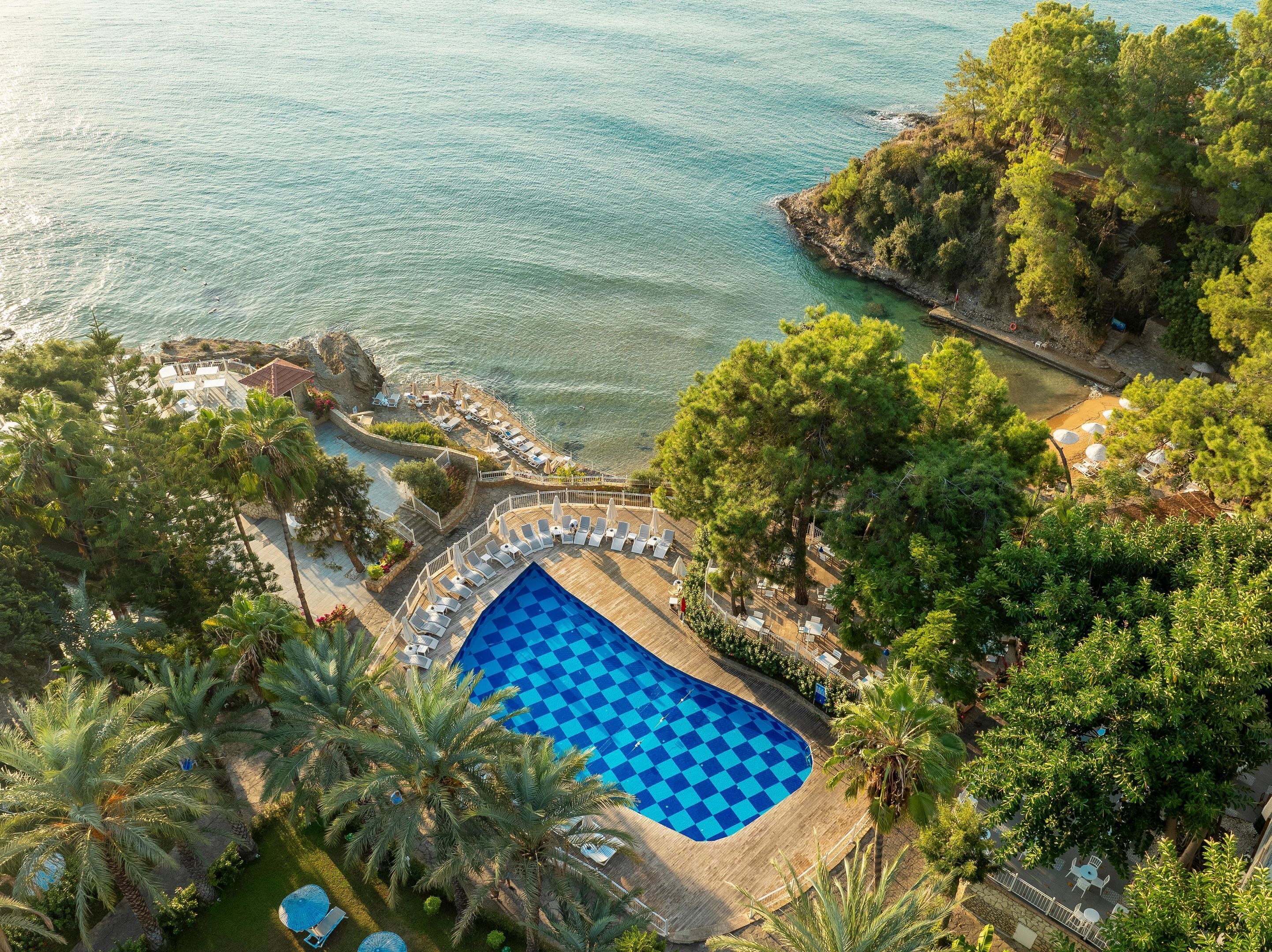 Ein Resort mit Pool, Liegestühlen und Meerblick.