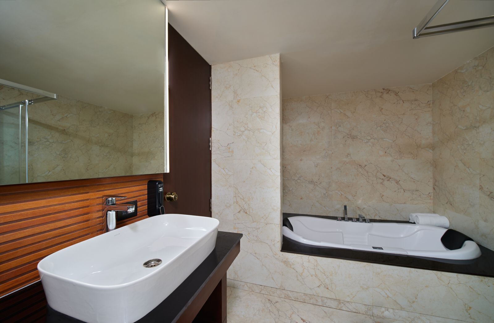 A modern bathroom with a freestanding bathtub, a large mirror, and a wooden vanity.