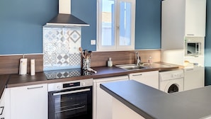 A modern kitchen with a built-in oven, a dishwasher, and a washing machine.