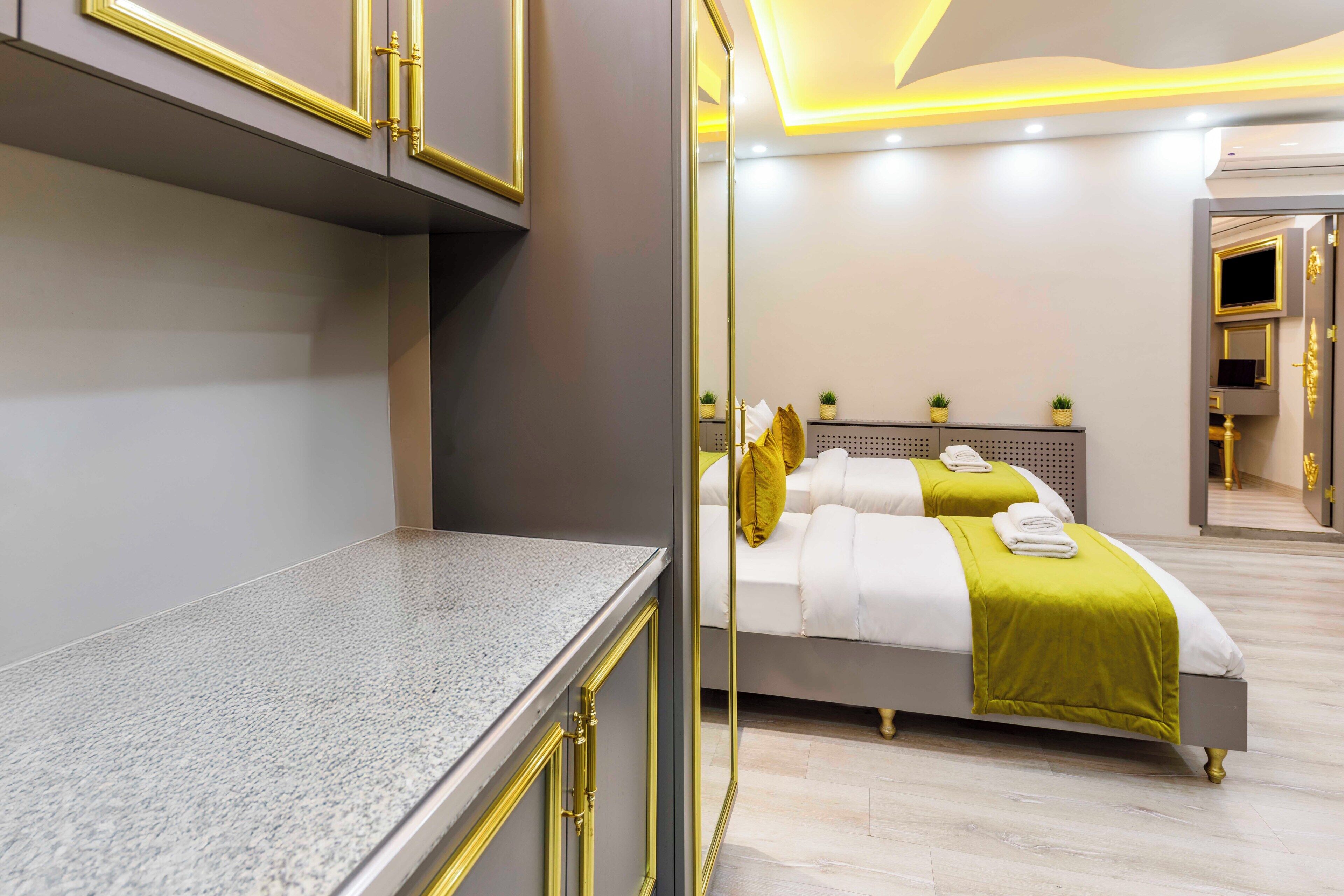 A modern hotel room with a bed, a vanity, and a mirror.