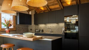 Una cucina moderna con isola centrale, sgabelli da bar e un'ampia finestra vista panoramica.