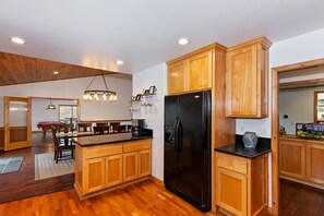 A modern kitchen with wooden cabinets, a black refrigerator, and a central island.