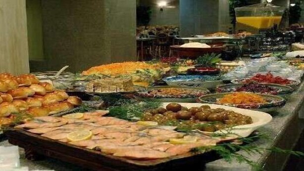 A buffet with various food items including seafood, fruits, and vegetables.