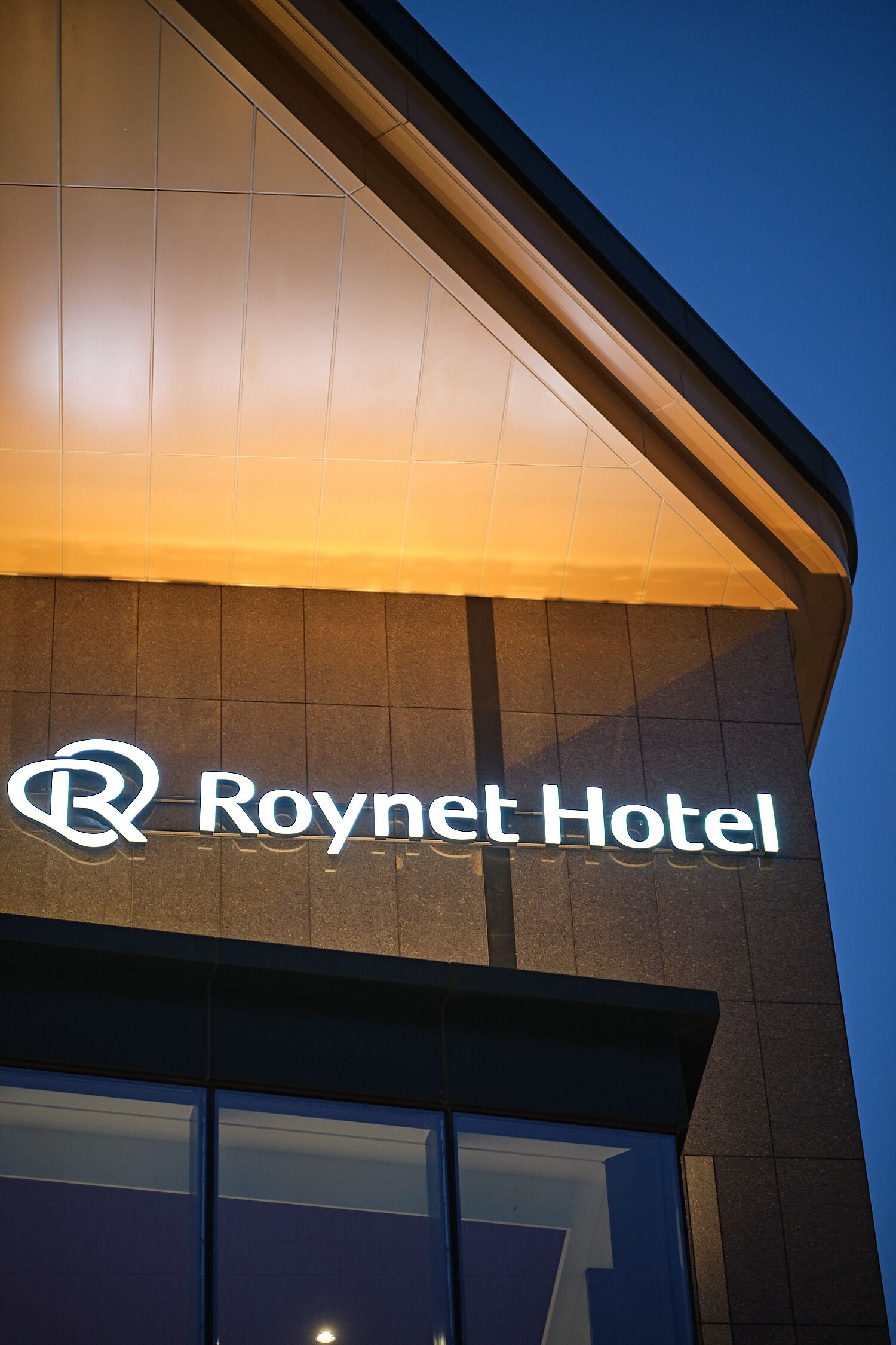 El exterior del Hotel Roynet con su letrero iluminado.