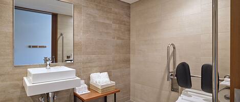 A modern bathroom with a sink, mirror, and toilet.