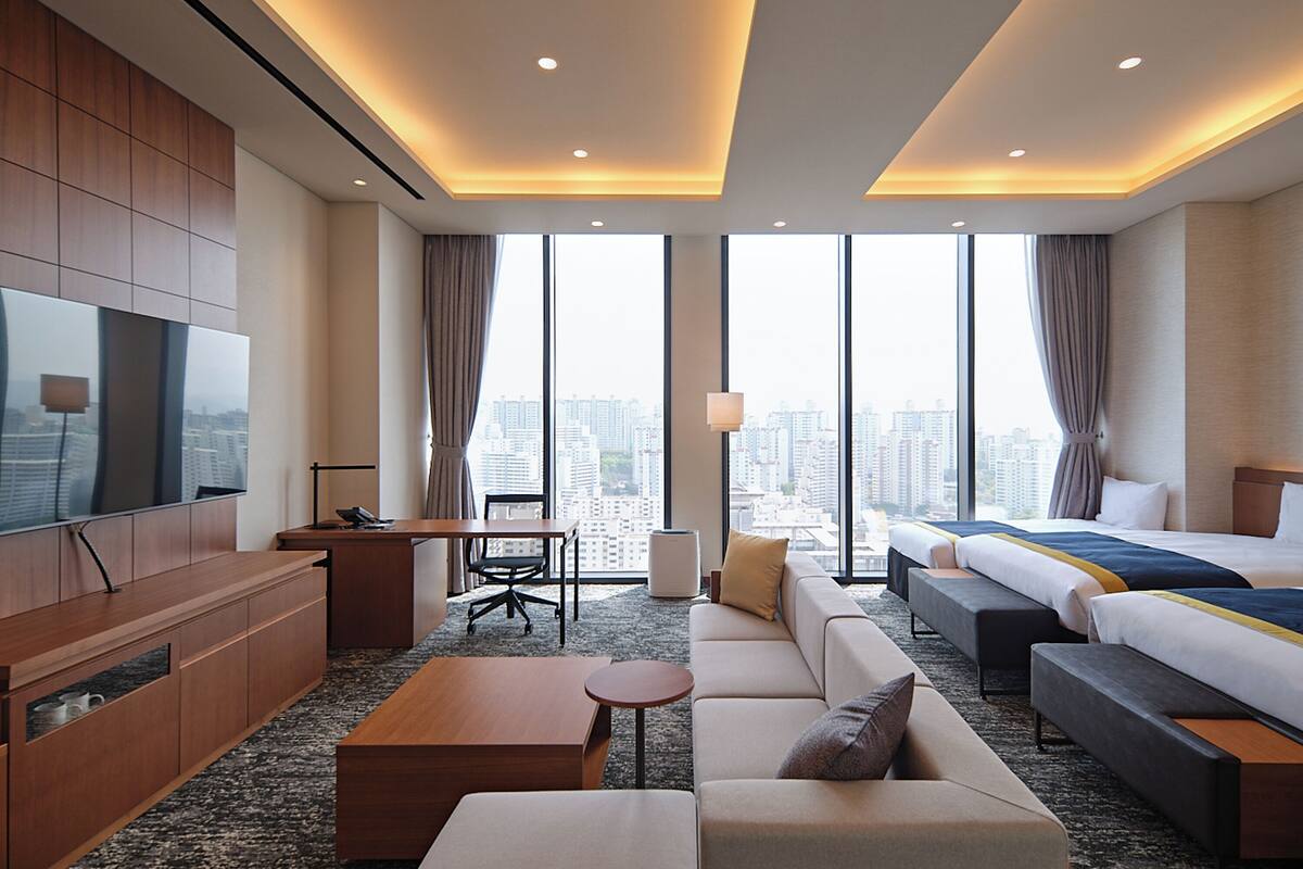 Une chambre d’hôtel moderne équipée d’un grand lit, d’un canapé, d’un bureau et d’une télévision.