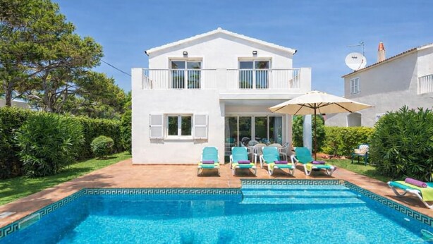 A two-story house with a swimming pool, a covered patio with chairs, and a satellite dish. - Villa Fina (Ciutadella de Menorca)