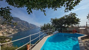 Ein Pool mit Blick auf eine Küstenstadt und Berge.