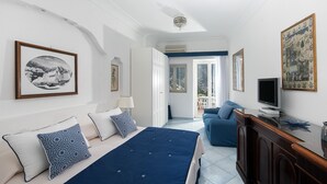 Ein Schlafzimmer mit Bett, Schreibtisch, Stuhl und Fernseher.