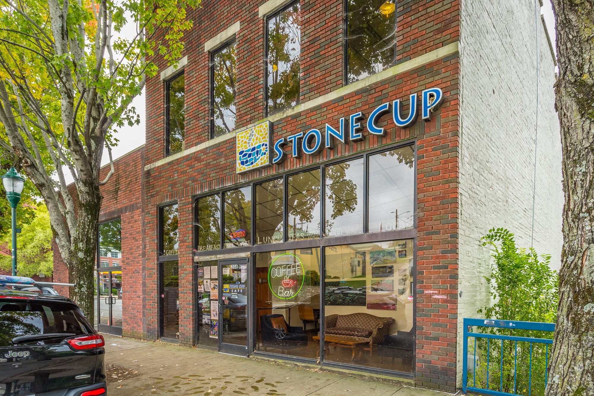 Un bâtiment en briques avec une grande vitrine en verre sur laquelle on peut lire l’inscription « STONE CUP ».