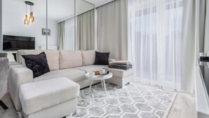 A modern living room with a sectional sofa, a small round coffee table, and a large mirror.