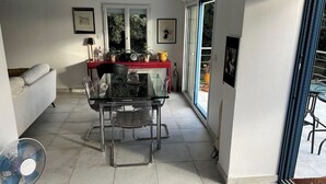 A modern kitchen with a glass dining table, clear chairs, and a red countertop. - Pretty Provencal house in a medieval village (Bouchet)