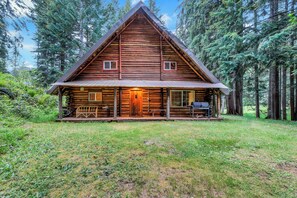 A log cabin with a porch, a chimney, and a small deck area. - Log Cabin Near Mount Rainier, Sleeps 8, Fireplace and Fire Pit (Ashford)