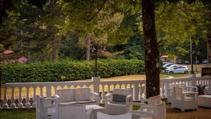 Outdoor seating with white wicker furniture and a white balustrade. - Il Bivacco del Parco Sport Hotel & Residence (Taverna)