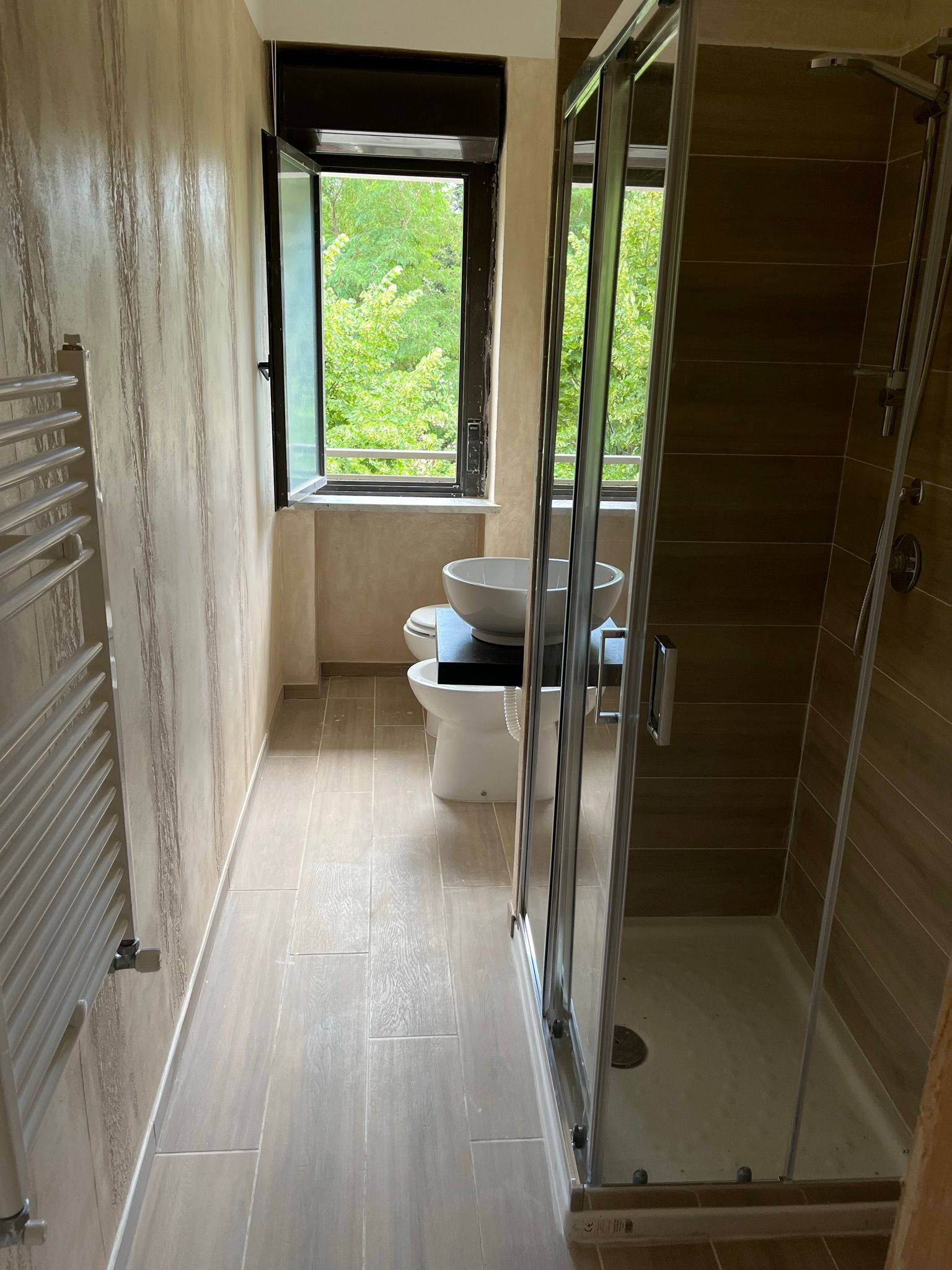 Un baño moderno con cabina de ducha de vidrio, un inodoro y un bidé.
