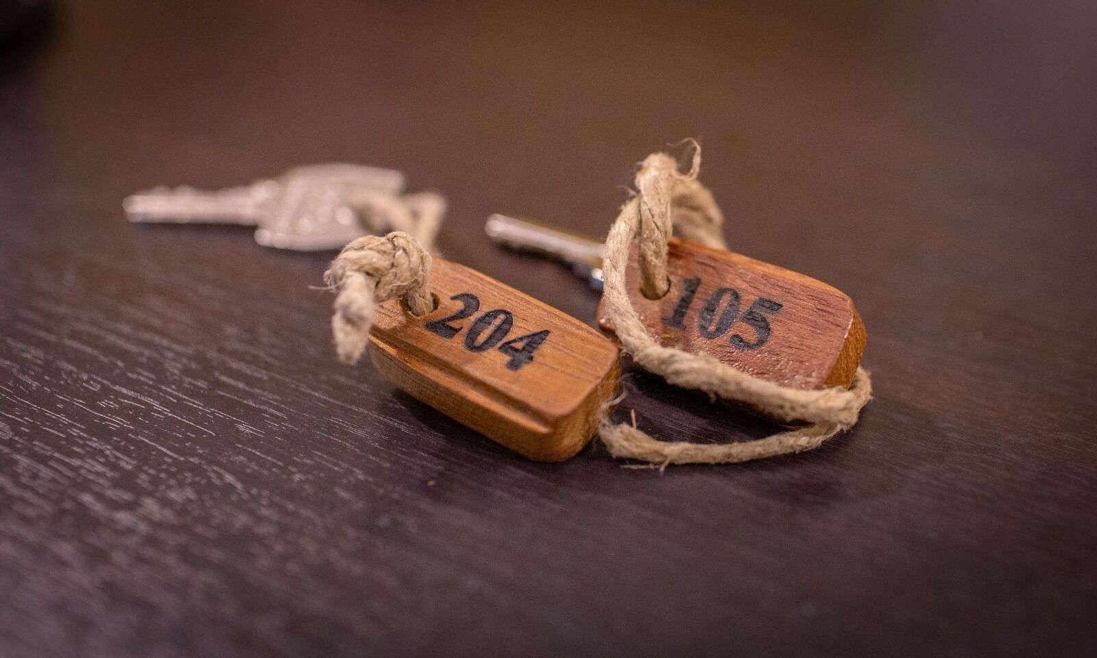 Two wooden tags with numbers 204 and 105 tied with twine.