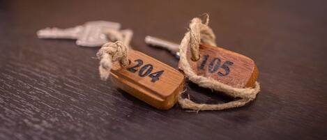 Two wooden tags with numbers 204 and 105 tied with twine.