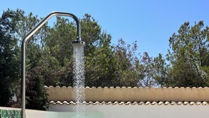 Un área de spa con un jacuzzi, una fuente de agua y escalones que bajan hacia un suelo cubierto de guijarros.