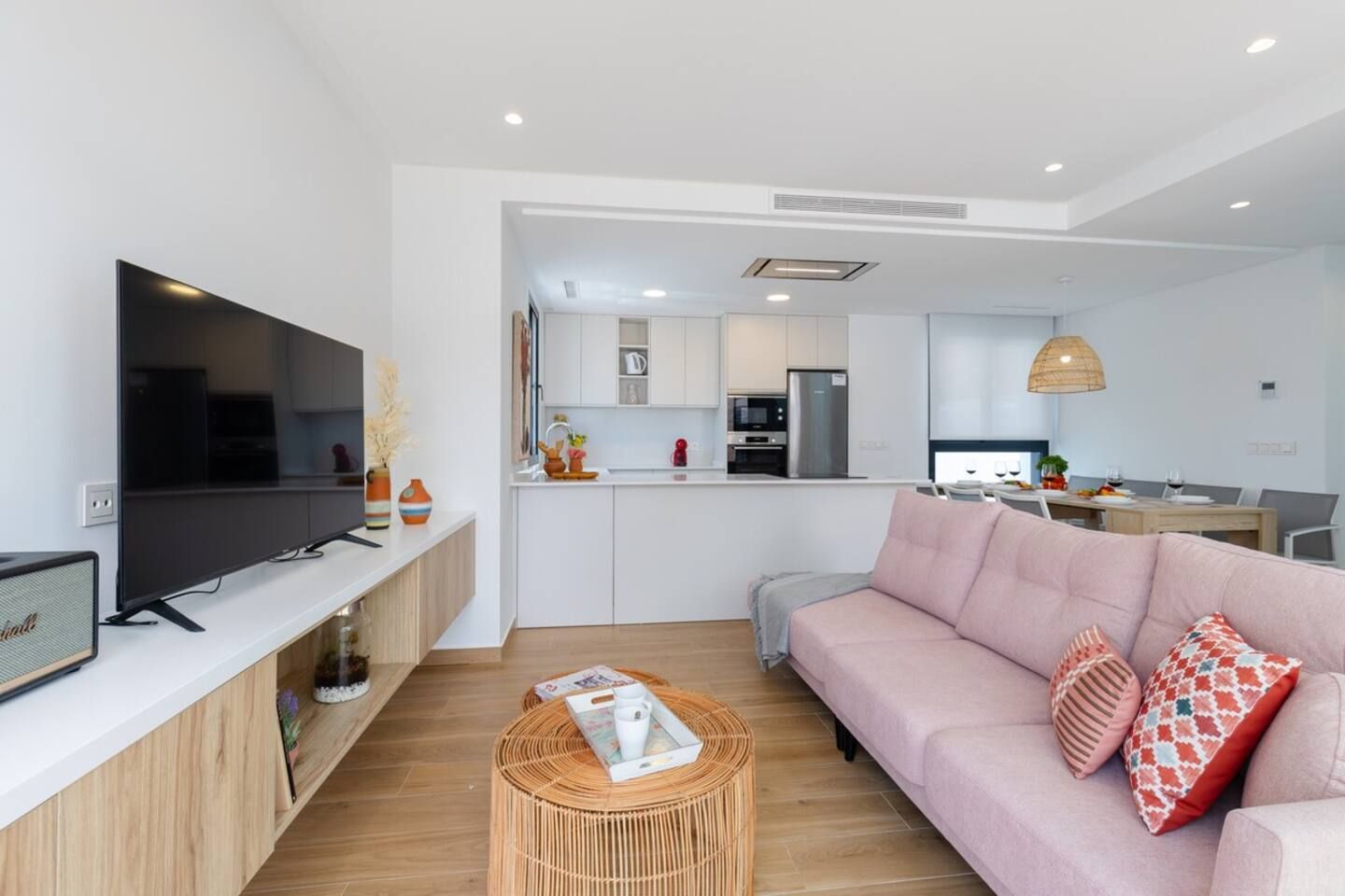 Una sala moderna con un televisor de pantalla plana, un sofá y una mesa de centro.