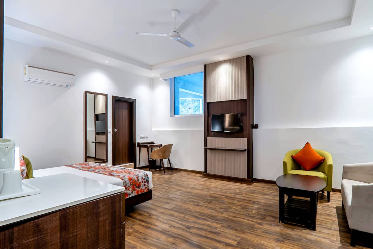 A modern hotel room with a bed, a desk, a chair, a TV, and a window with a view.
