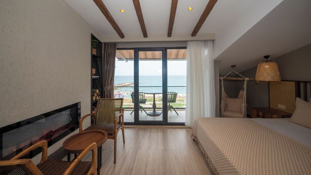 A hotel room with a balcony, a bed, a TV, and a seating area with chairs and a table. - Villa Siesta Hotel Istanbul Airport (Arnavutköy)