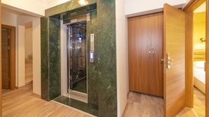A hotel room with a wooden wardrobe, a marble wall, and a built-in elevator. - Bazaar Hotels Old City (Istanbul)
