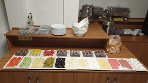 A buffet setup with various food items and utensils. - Bazaar Hotels Old City (Istanbul)