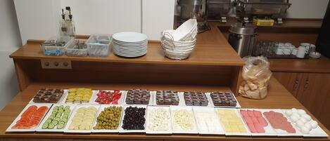 A buffet setup with various food items and utensils.