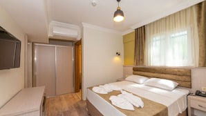 A hotel room with a bed, bedside table, and a TV mounted on the wall. - Bazaar Hotels Old City (Istanbul)