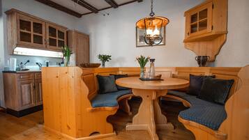 A wooden kitchen with a built-in bench seating area around a central table.