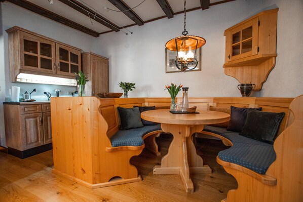 A wooden kitchen with a built-in bench seating area around a central table. - Burg Gutenfels (Kaub)