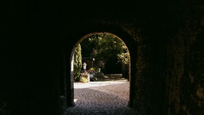 Un arco in pietra conduce a un sentiero lastricato.