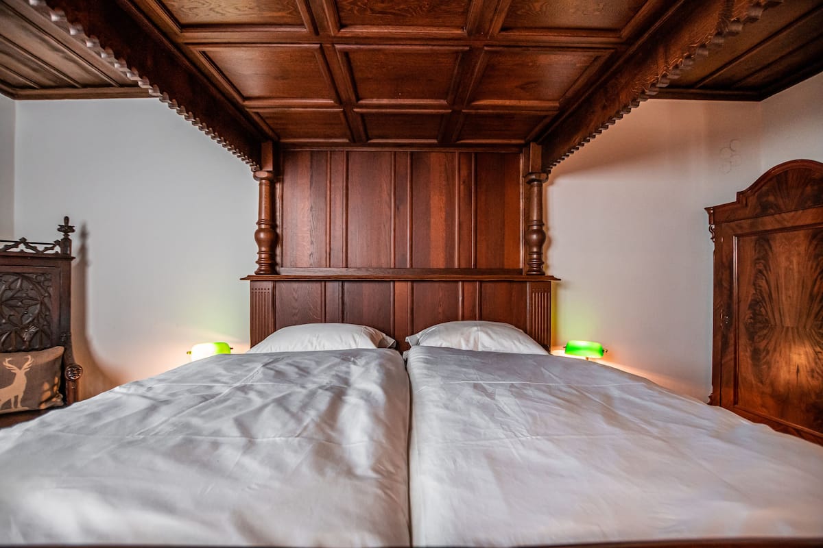 A double bed with a wooden headboard and two bedside lamps.