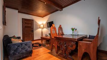 Un coin repas avec une table et des chaises en bois, une lampe et un canapé.
