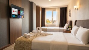 A hotel room with a bed, a TV mounted on the wall, a window with curtains, and a view of the city. - Nostalji Suit Avcılar (Istanbul)